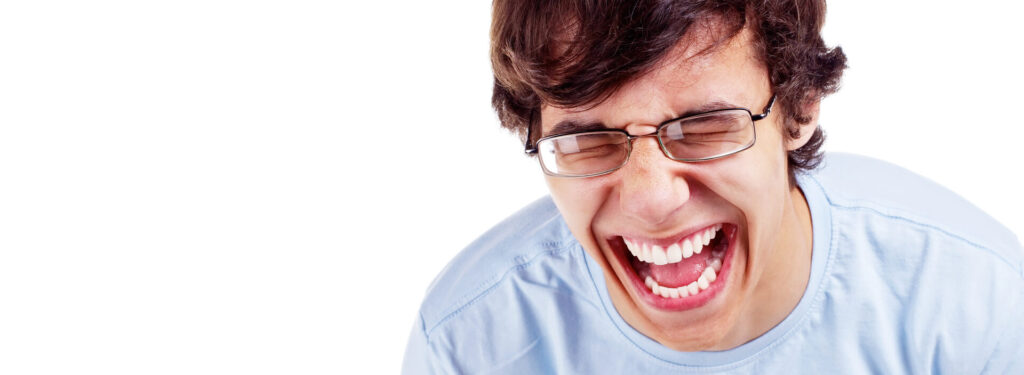 Lachender junger Mann mit Brille